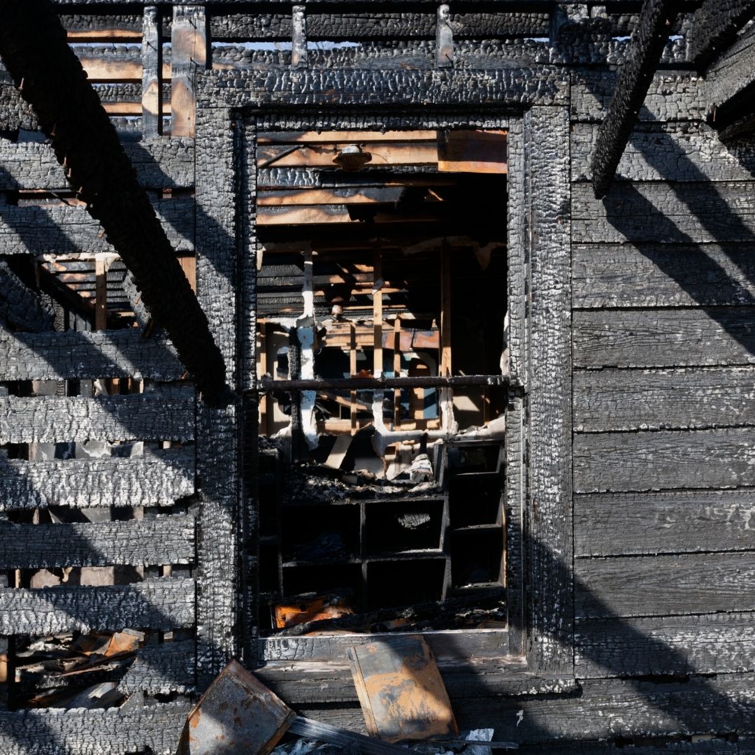 the ruins of a burned wooden house